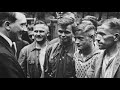 Hitler engaging with young men, symbolizing early indoctrination and conformity within the regime.