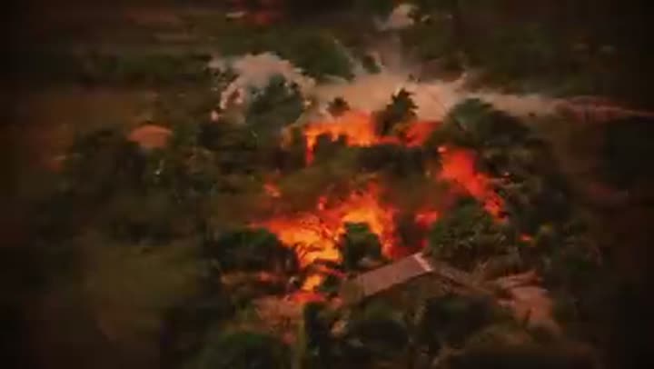 Aerial view of a village engulfed in flames, a terrifying scene of destruction.