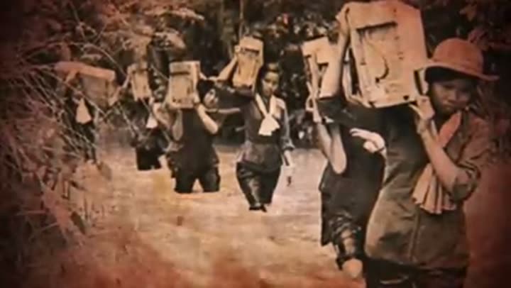 Vietnamese women carrying heavy loads through water, supporting the elusive Viet Cong.