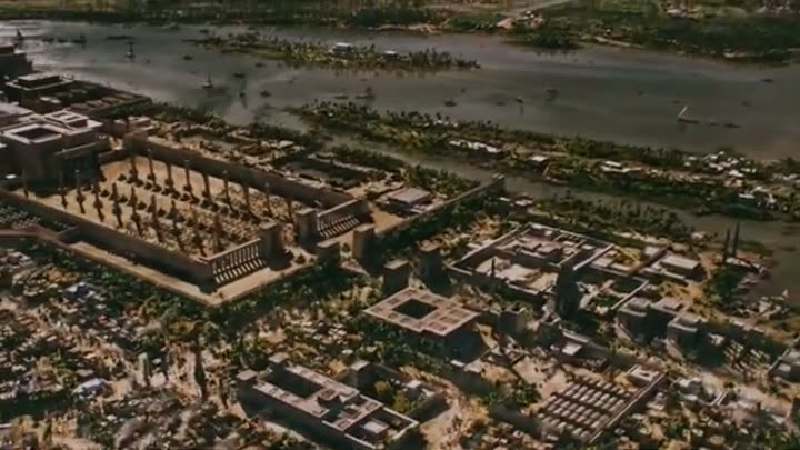 Aerial view of a grand ancient Egyptian city, likely Alexandria, beside the Nile.